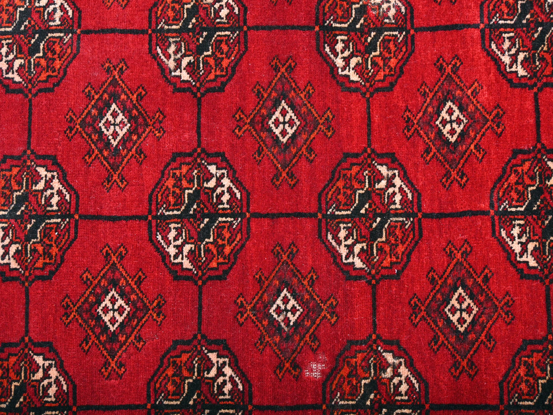 a close up of a red rug with a design on it