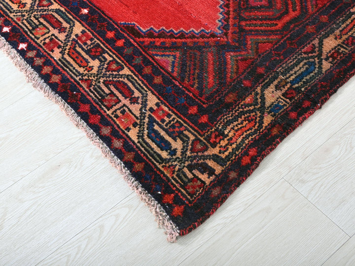 a red and blue rug on a white floor
