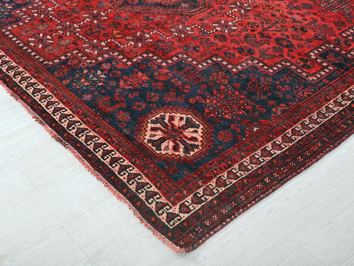 a red and blue oriental rug on a white floor