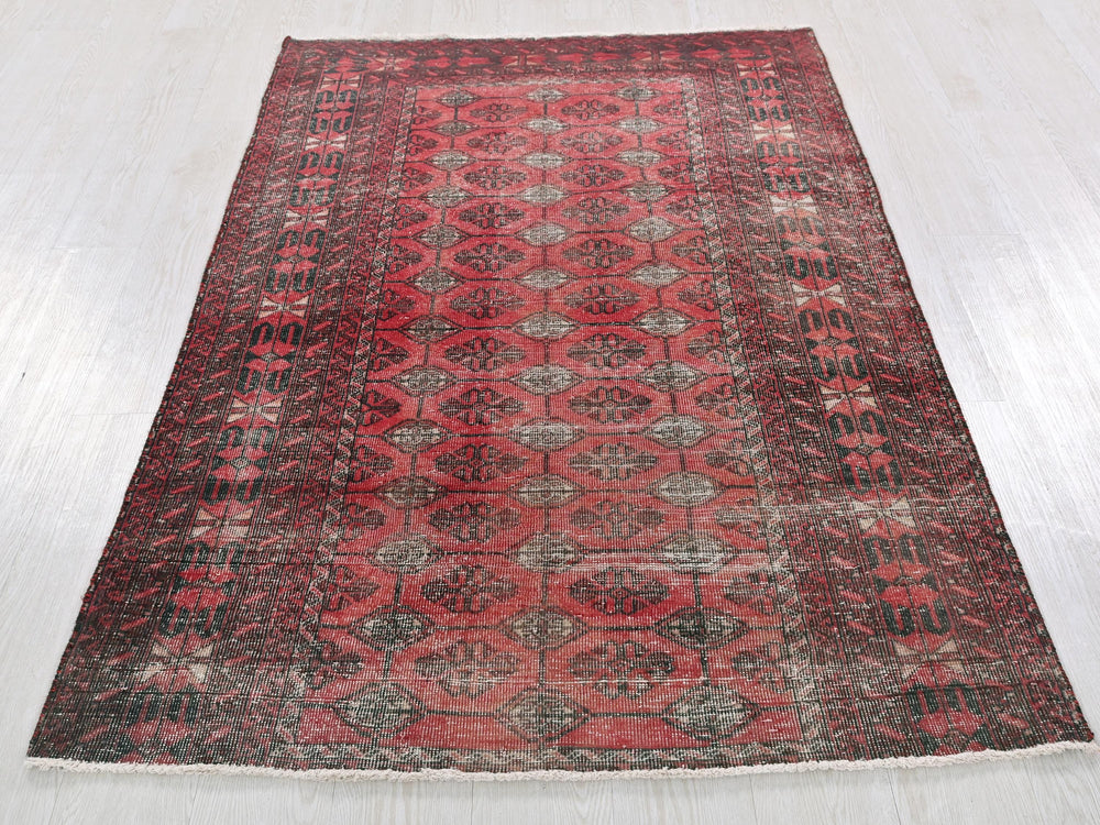a red and black rug on a white floor