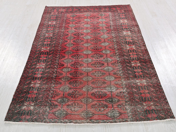 a red and black rug on a white floor