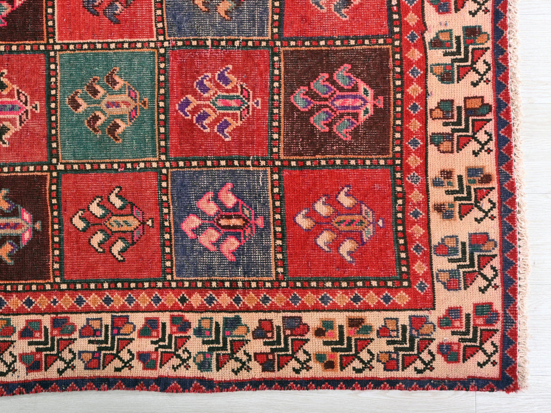 a red and blue rug on a white surface