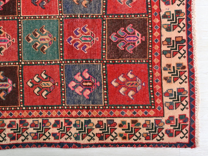 a red and blue rug on a white surface