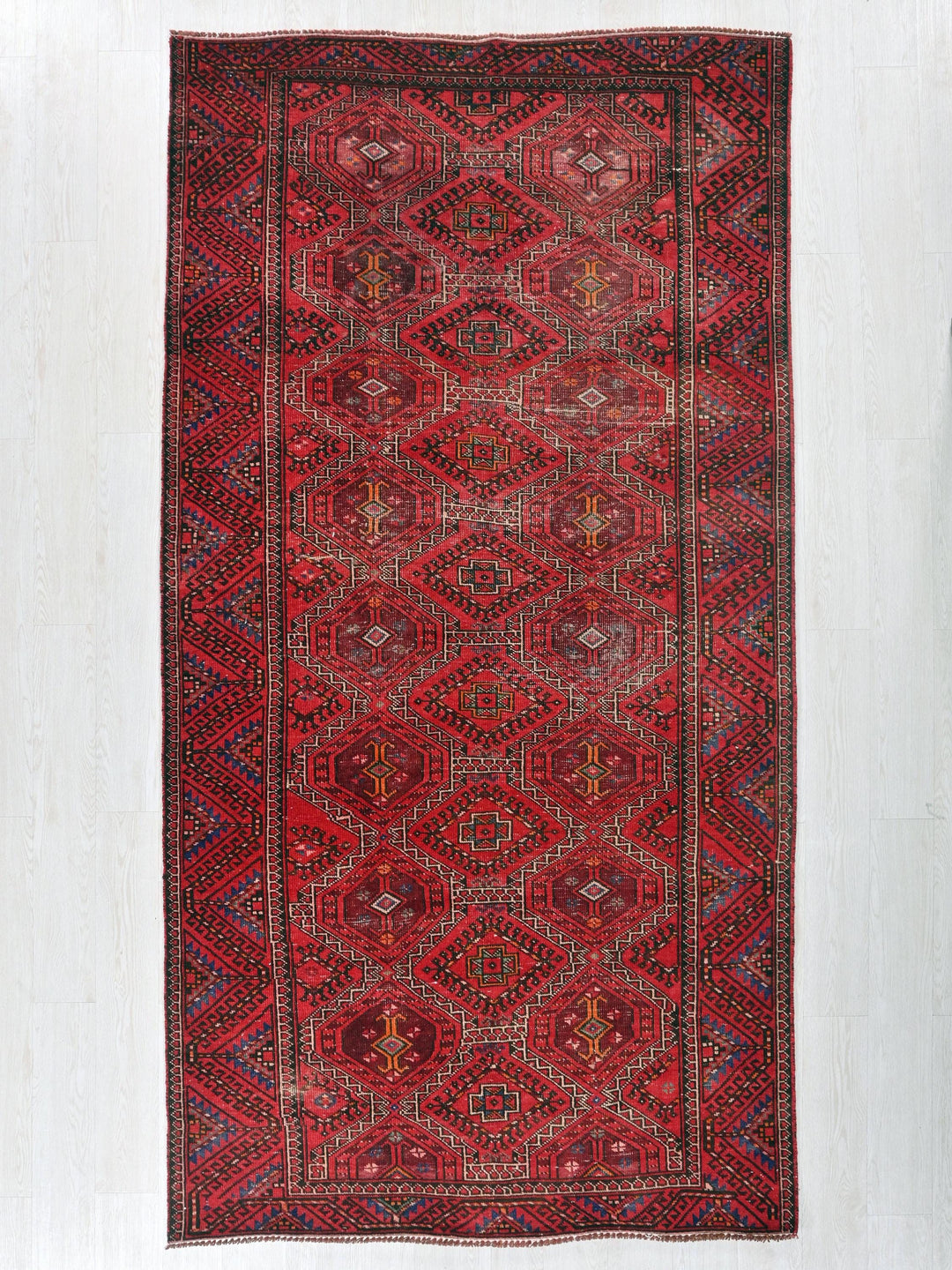 a red rug with a diamond pattern on it