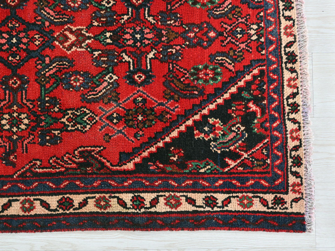 a red rug with a black border on a white background