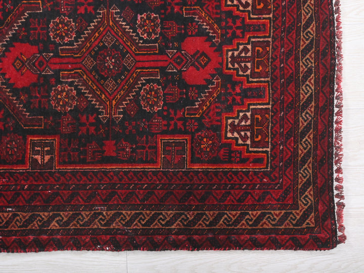 a red and black rug on a white floor