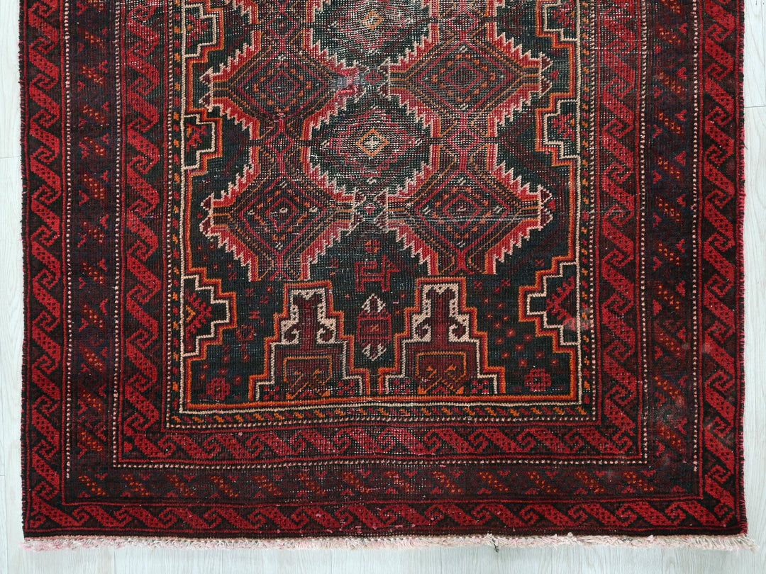 a red and black rug on a white wall