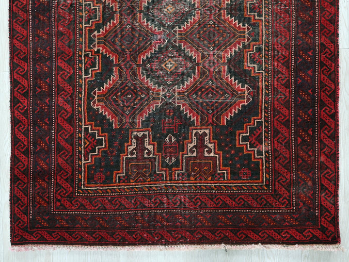 a red and black rug on a white wall