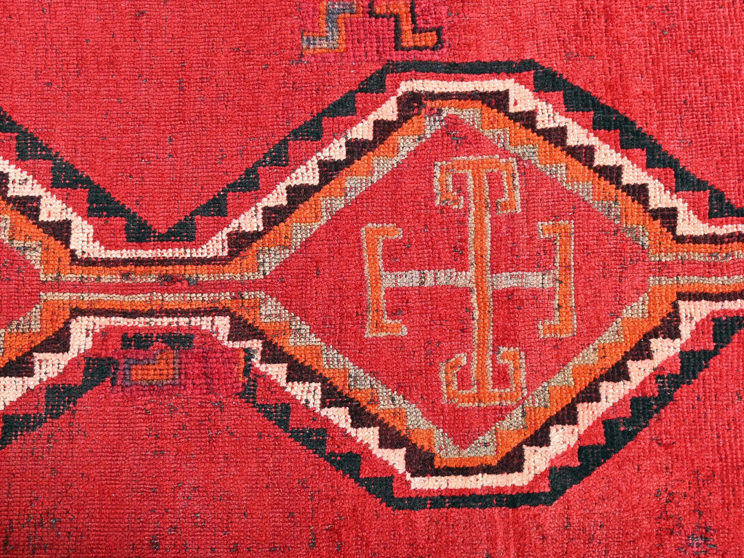 a close up of a red rug with a design on it