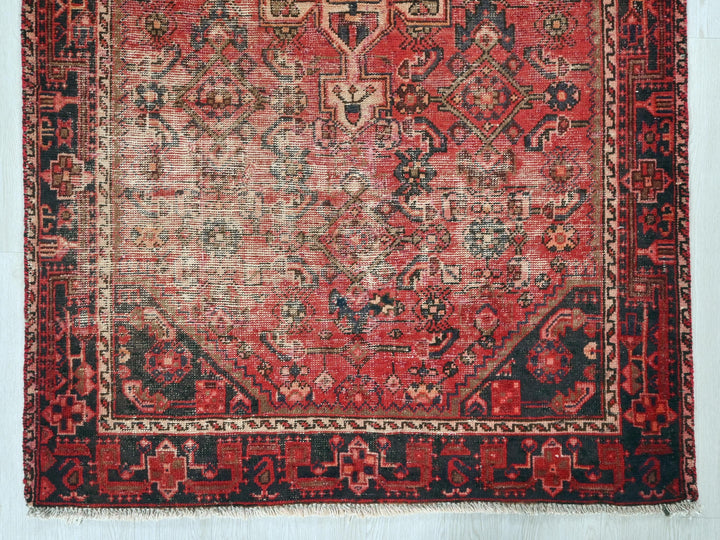 a red rug with a black border on a white background
