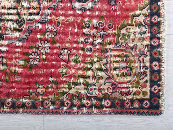a red rug with a floral design on it