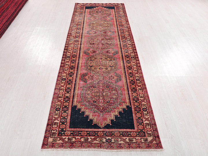 a red and black rug on a white floor