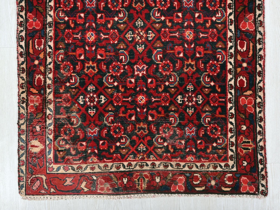 a red and black rug on a white floor