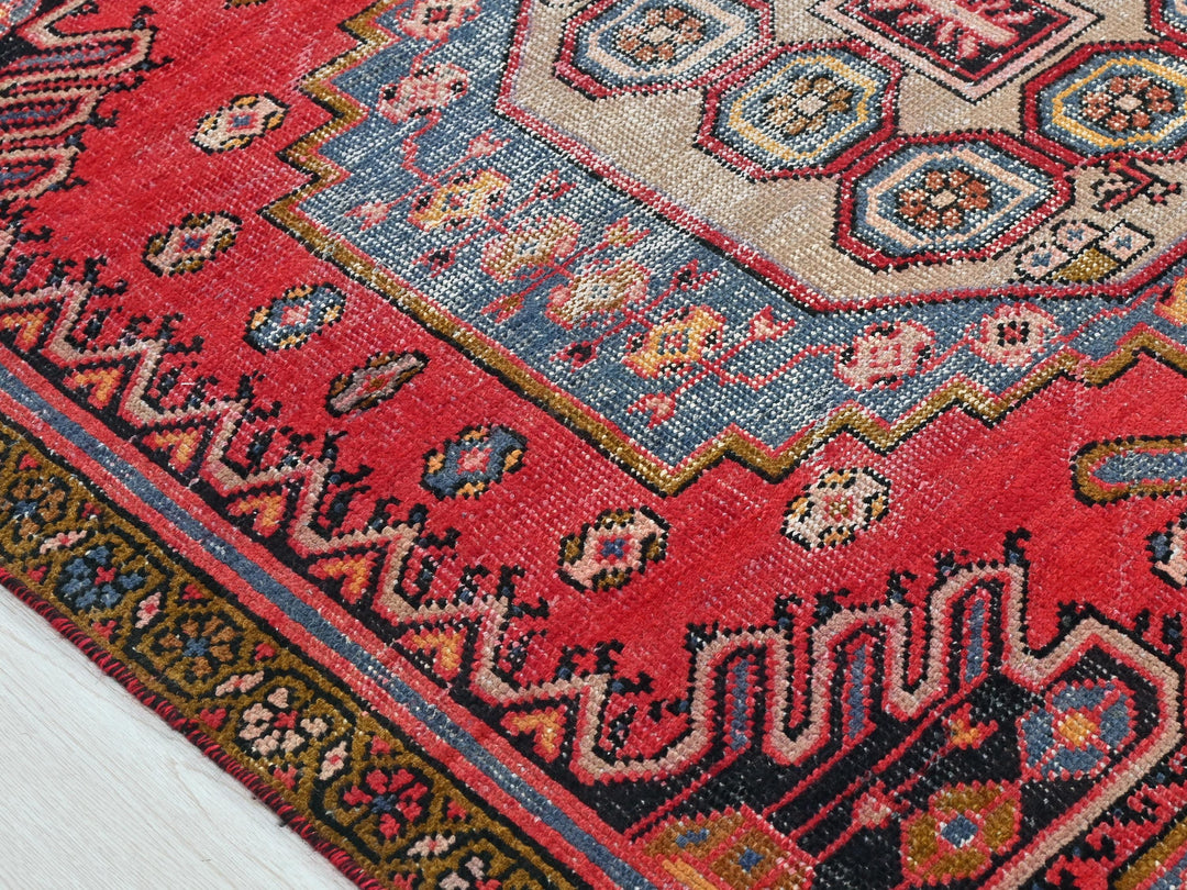 a red rug with a blue and yellow design on it