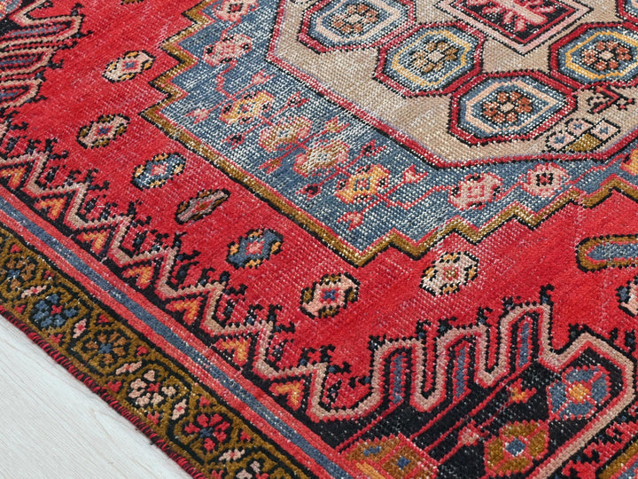 a red rug with a blue and yellow design on it