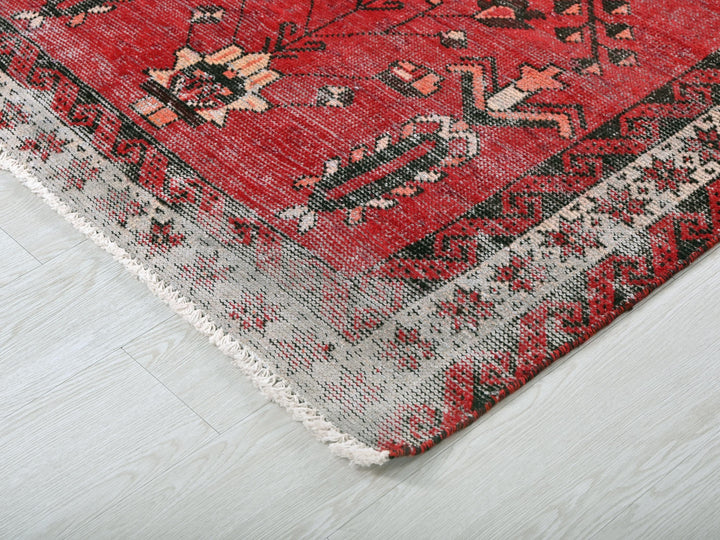 a red rug on a white wooden floor
