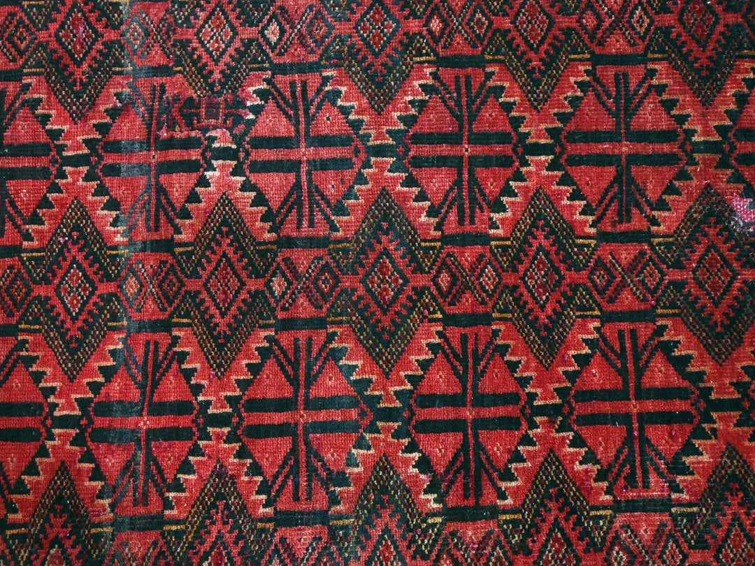 a red, black and white rug with a design on it