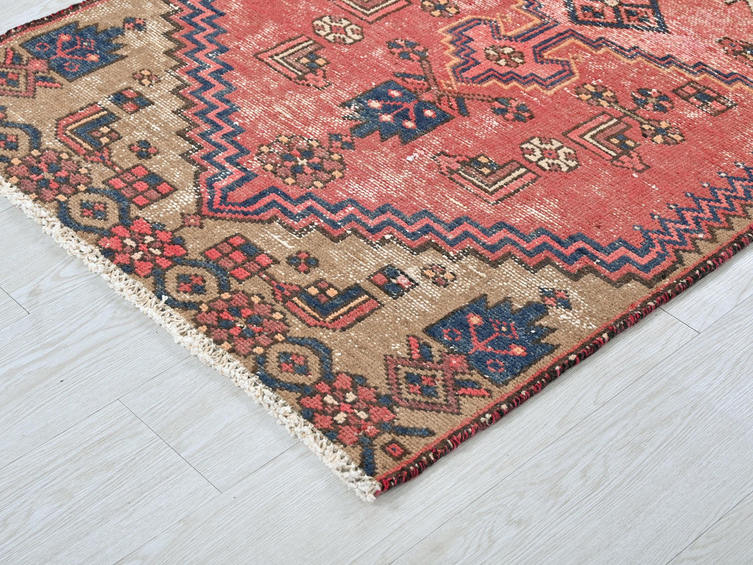 a red and blue rug on a white floor