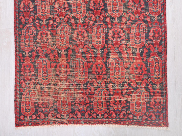 a red and black rug on a white floor