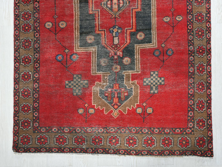 a red rug with a design on the middle of it