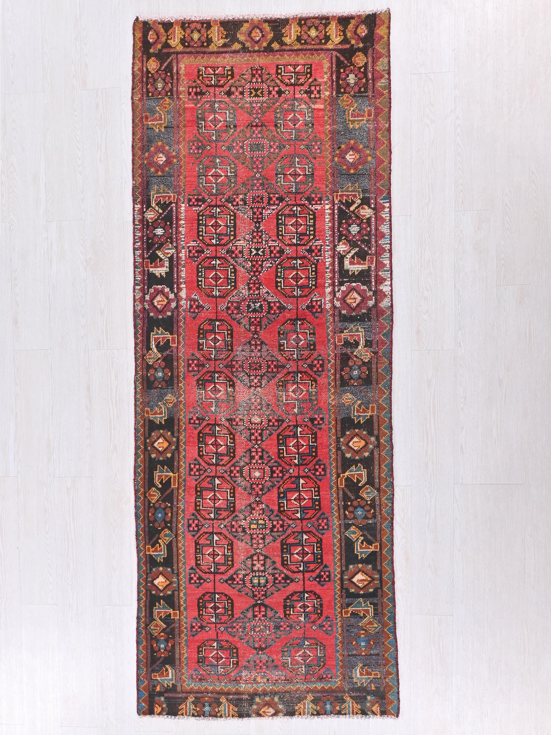 a red rug hanging on a white wall