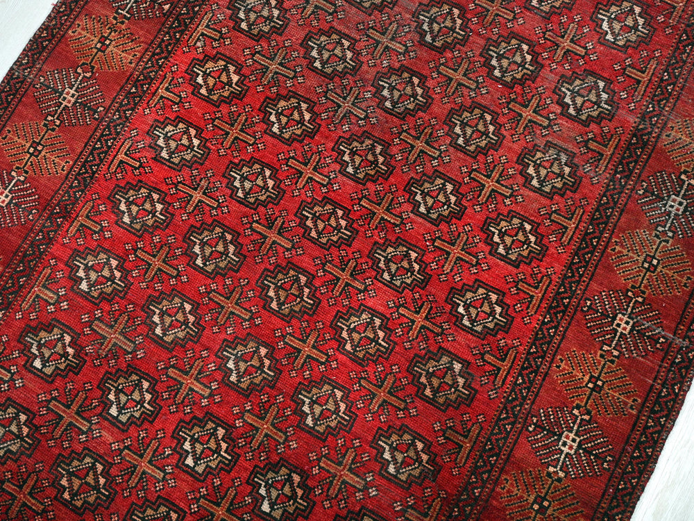 a red rug with a pattern on it