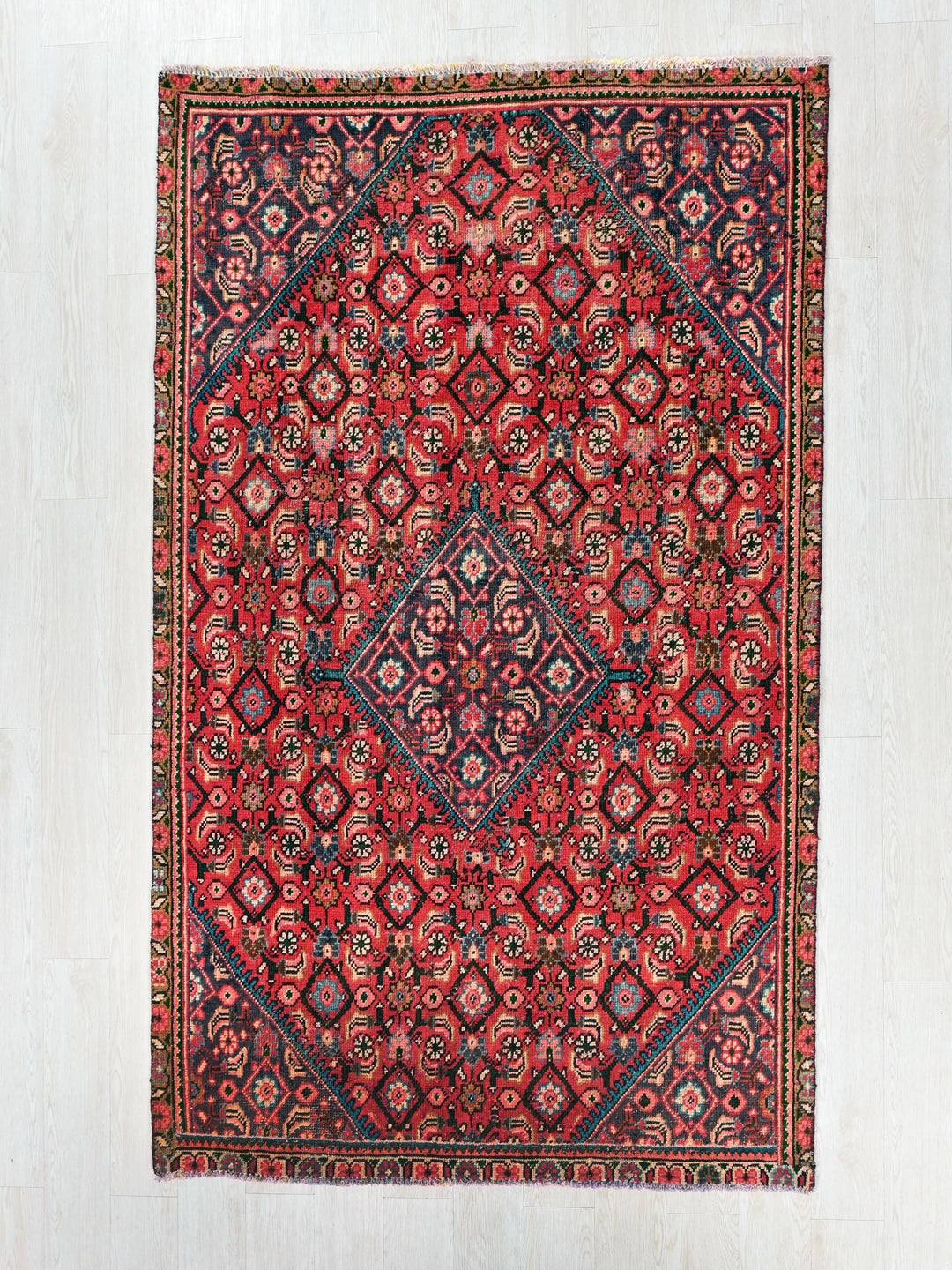 a red and blue rug with a diamond design