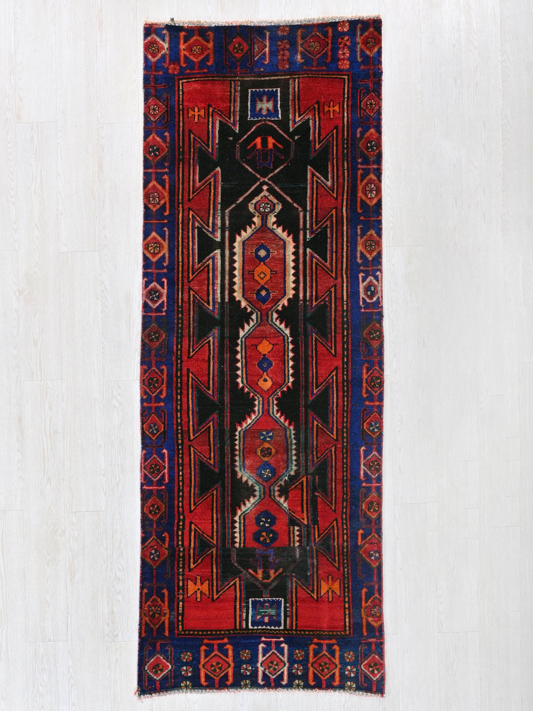 a red and black rug hanging on a wall