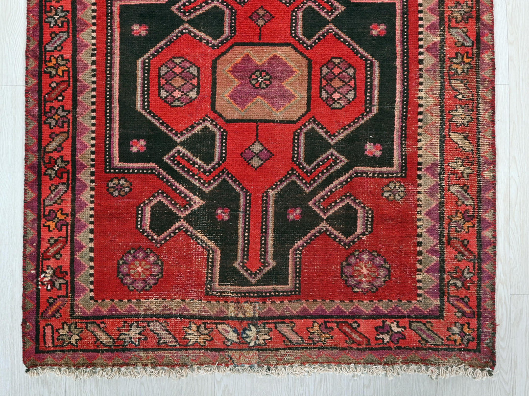 a red and black oriental rug hanging on a wall