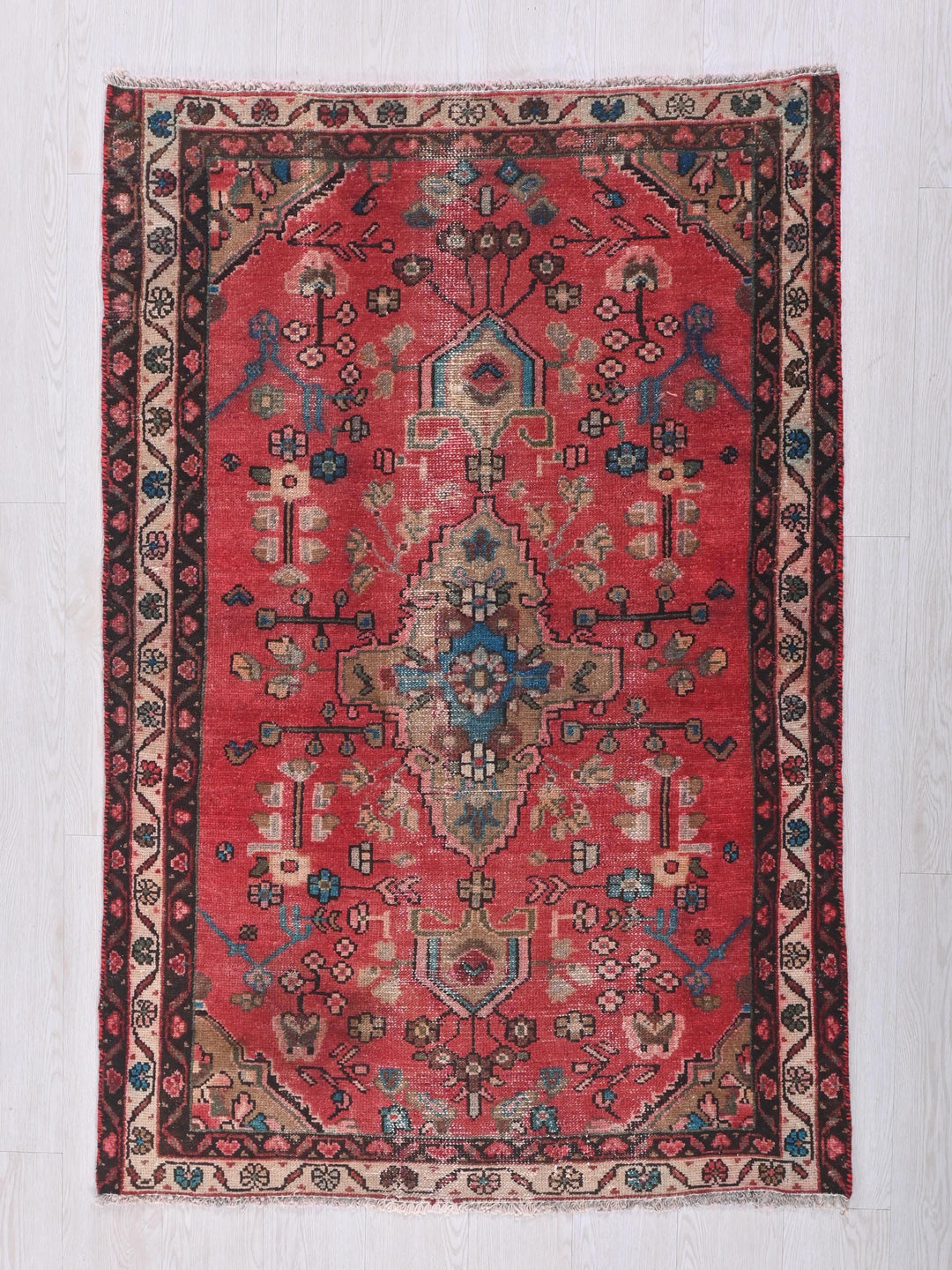 a red rug with a floral design on it