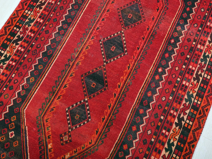 a red rug with a black and red design on it