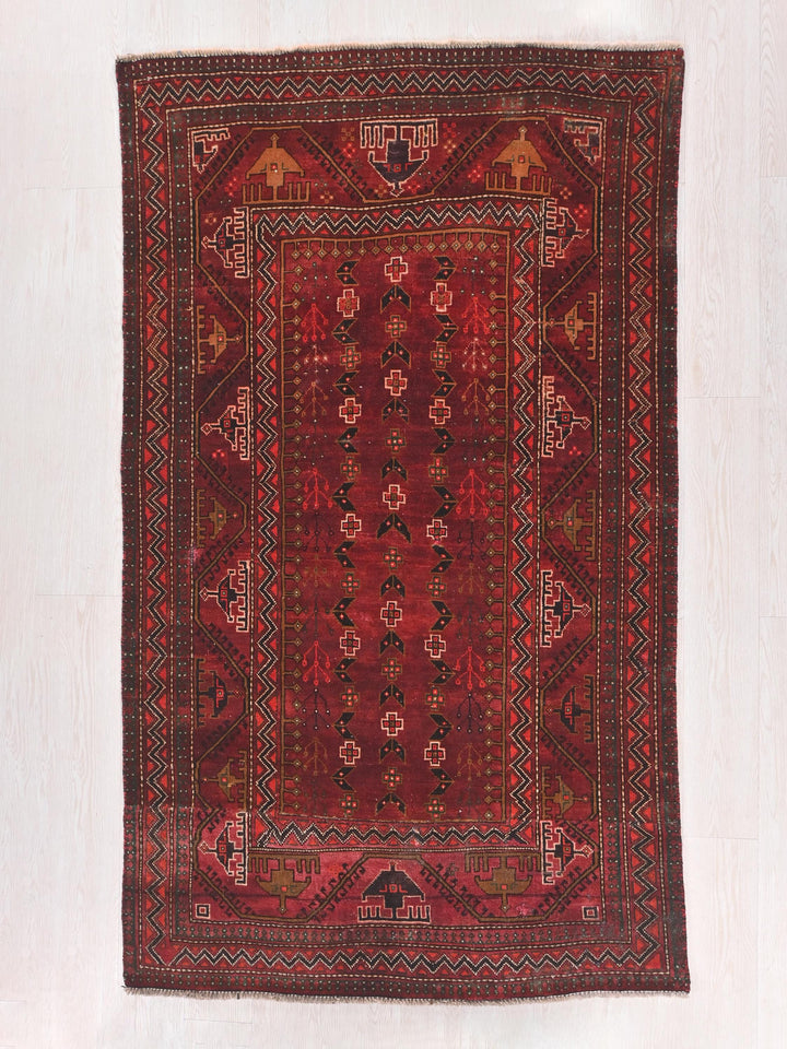 a red rug with a design on the middle of it