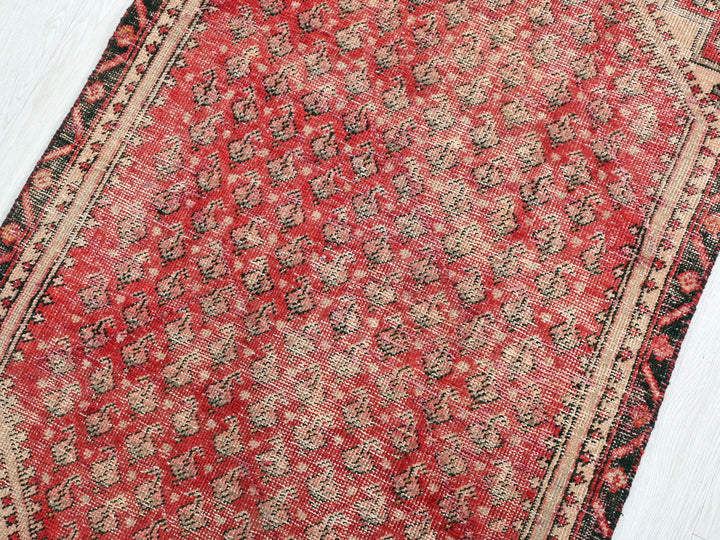 a red and black oriental rug on a white floor