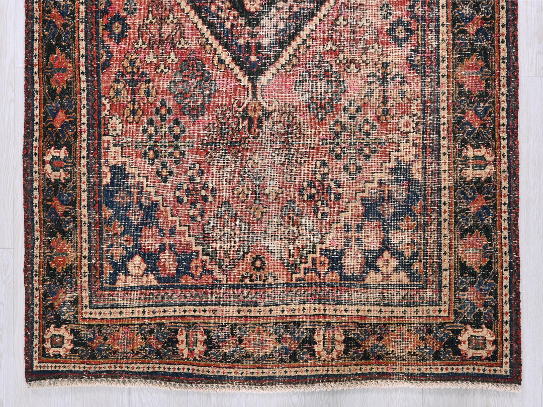an antique persian rug with a red, blue, and beige design