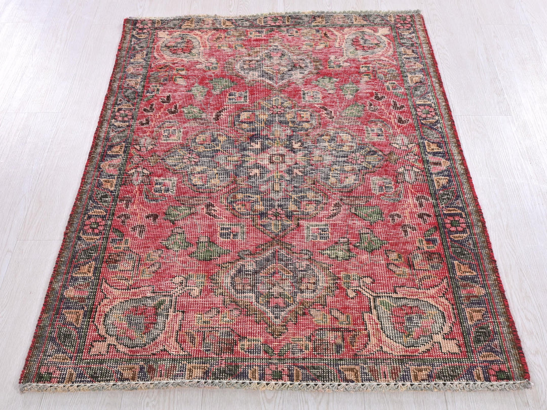 a red rug on a white wooden floor