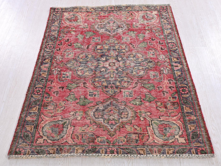 a red rug on a white wooden floor