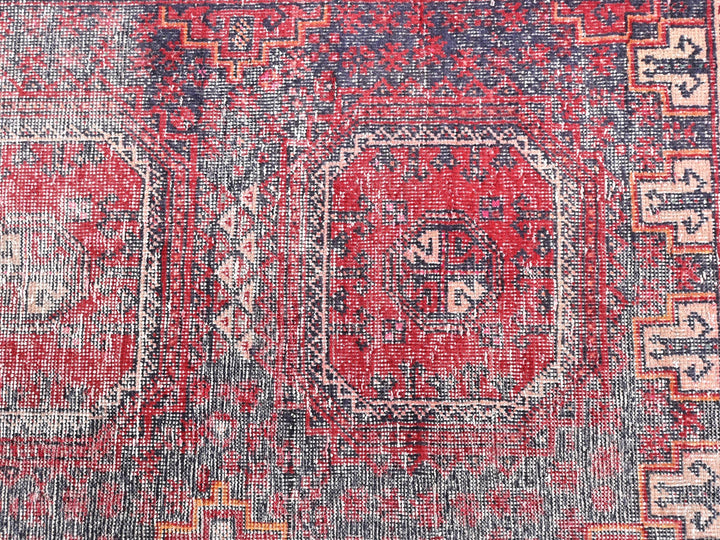 a red and blue rug with a design on it