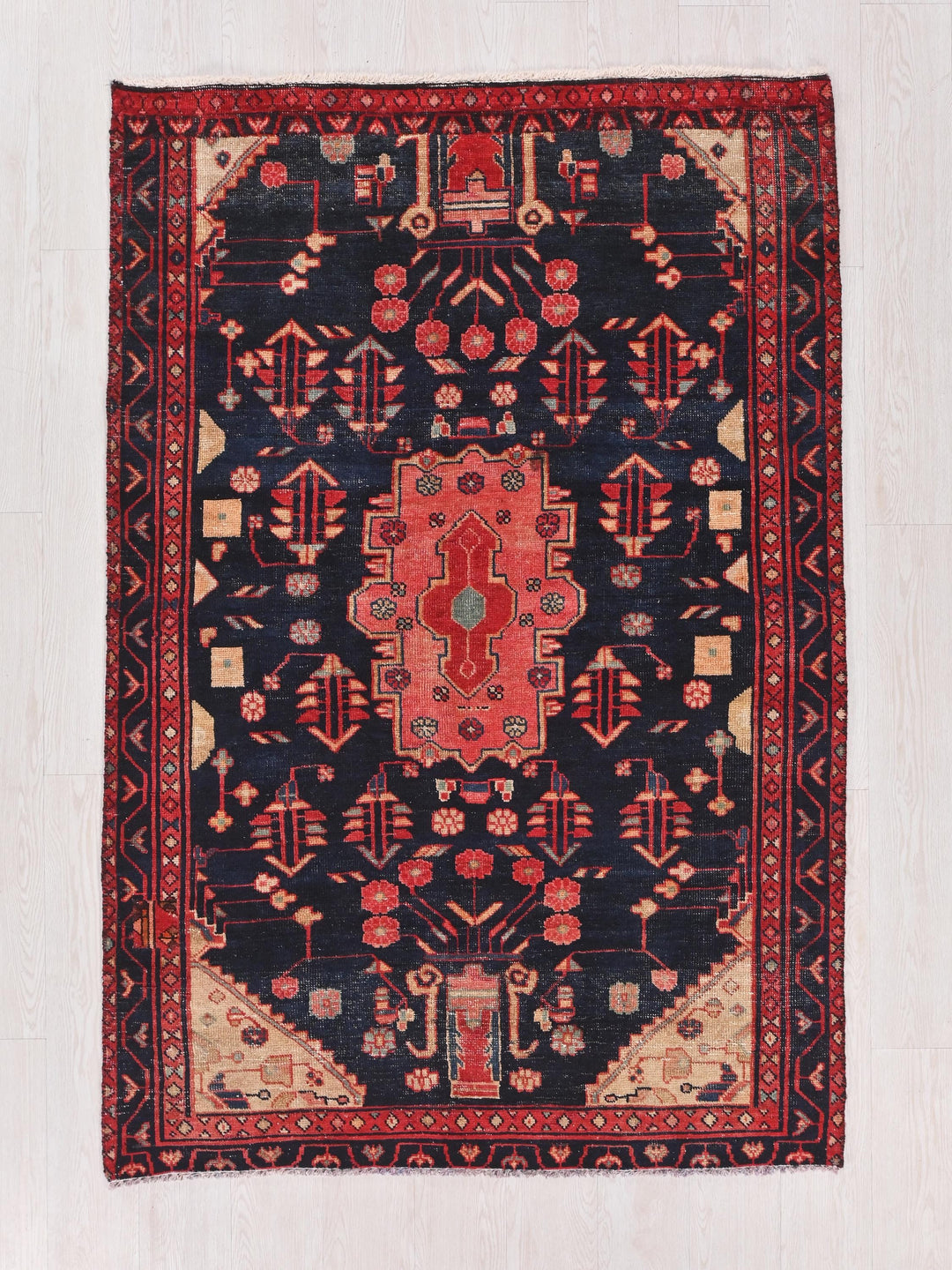 a red and black oriental rug on a white floor