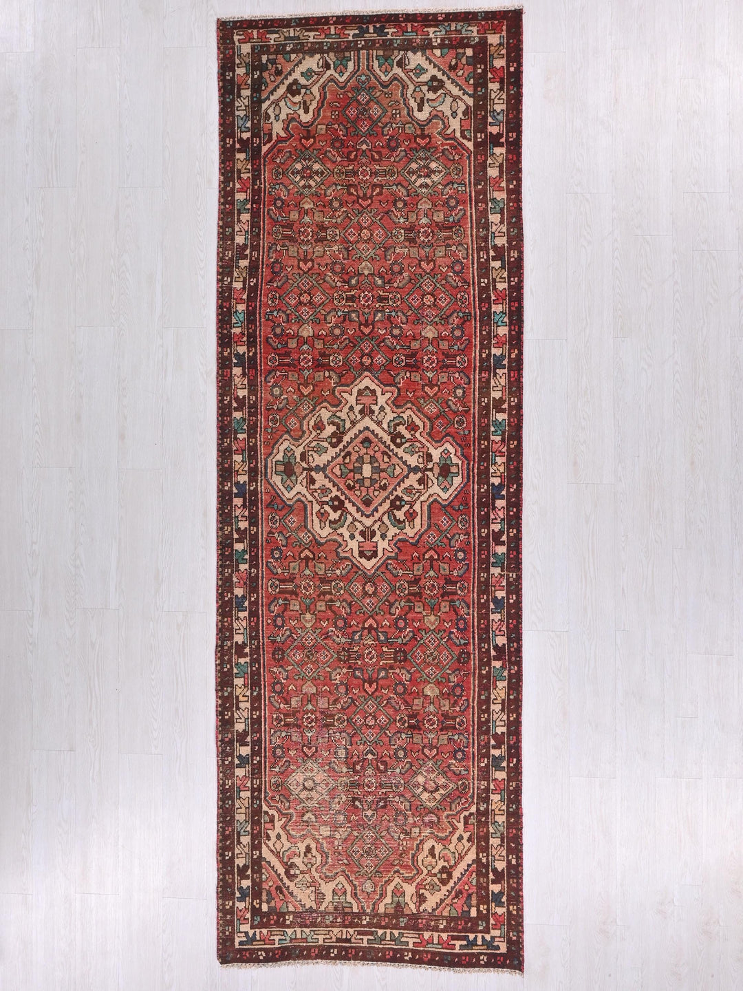 a red oriental rug hanging on a wall