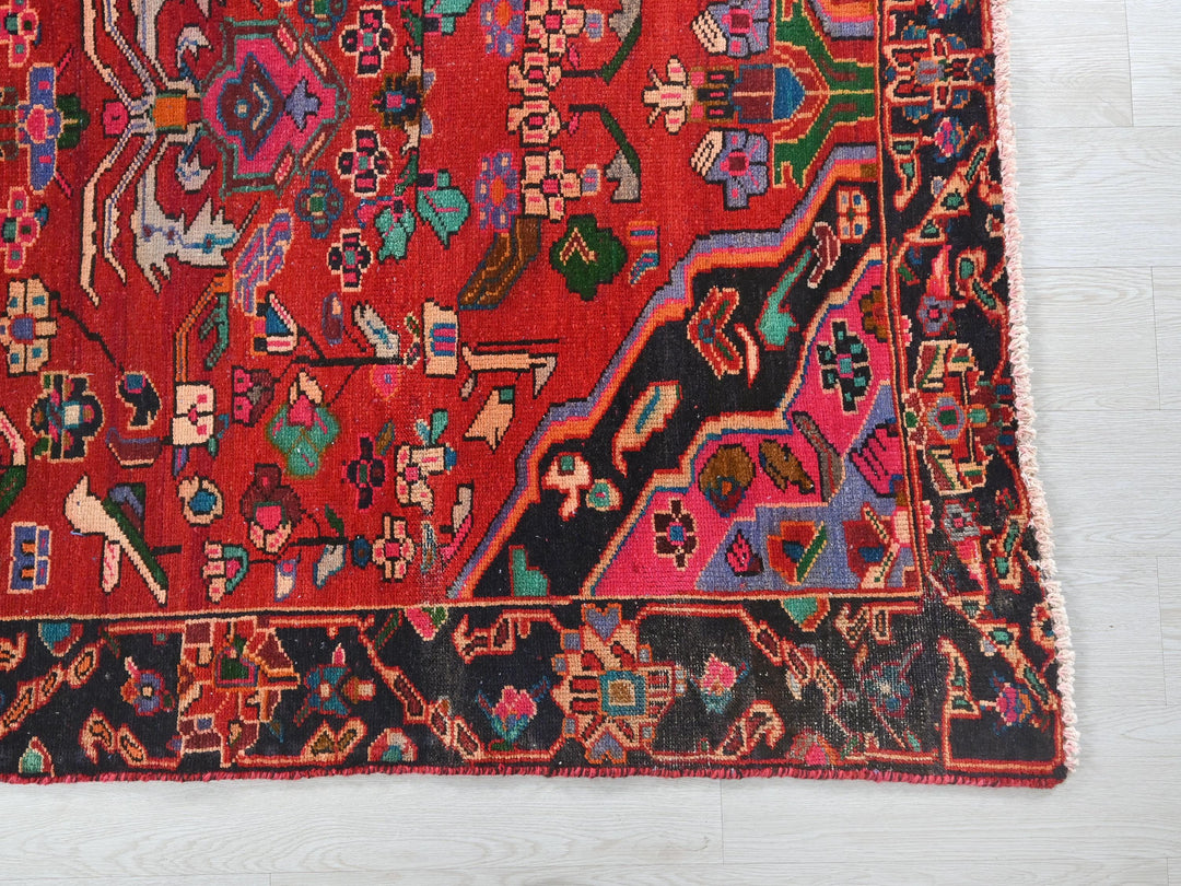 a red rug with a design on the middle of it