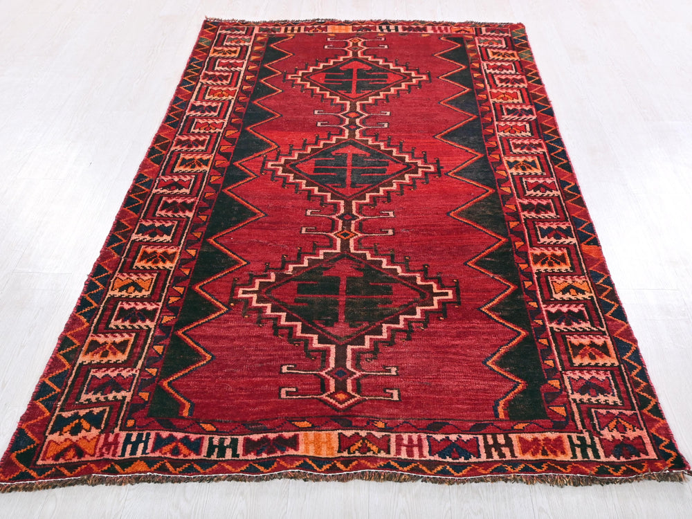 a red and black rug on a white floor