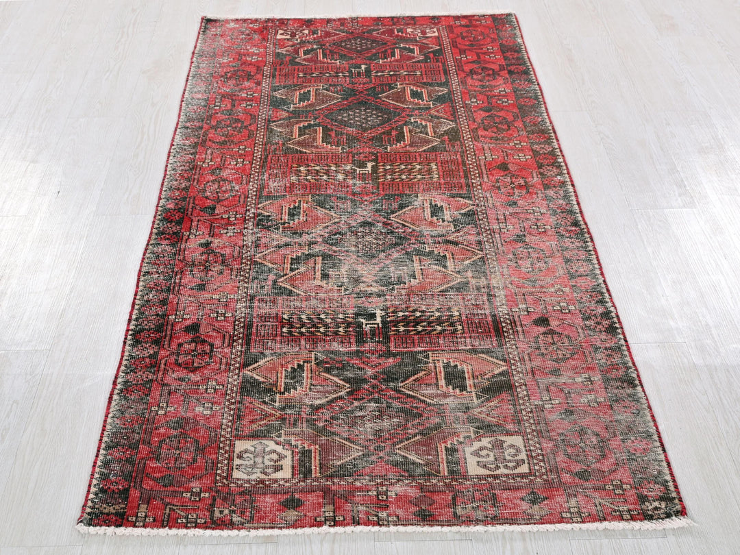 a red and black rug on a white floor