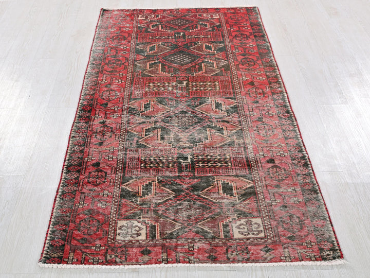 a red and black rug on a white floor