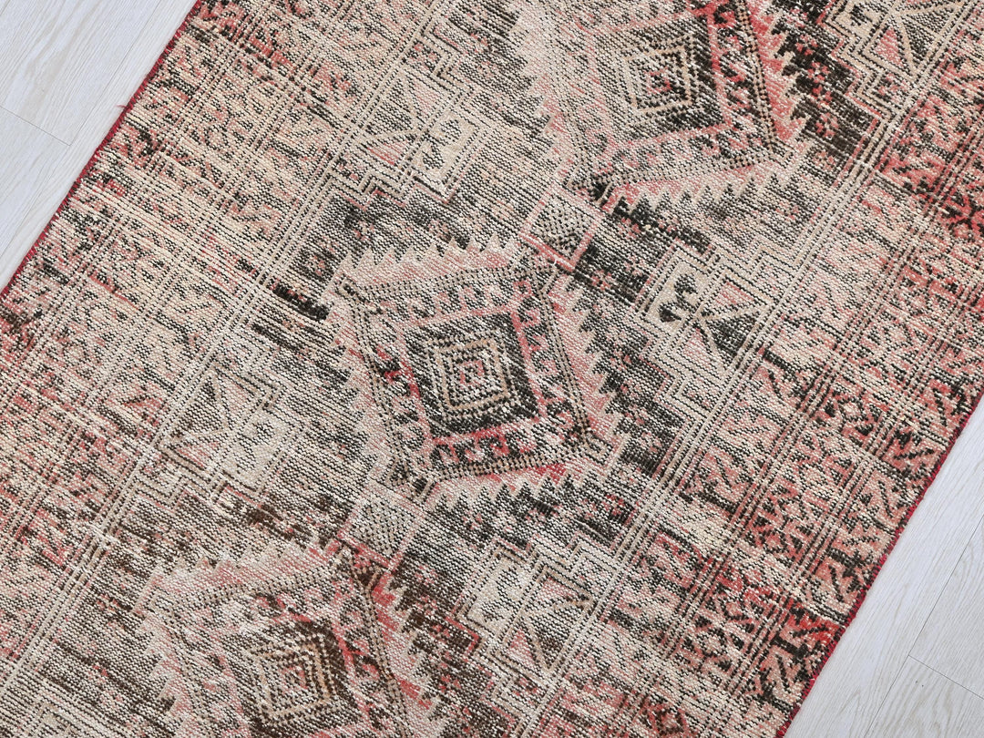 a red and black rug on a wooden floor