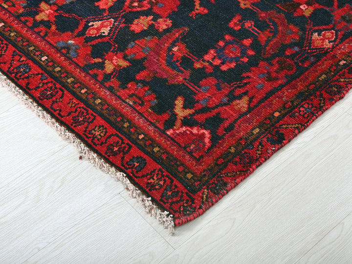 a red and black oriental rug on a white floor