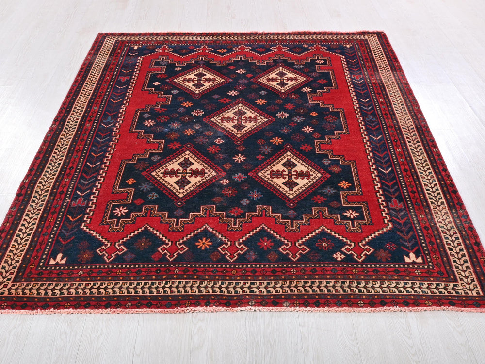 a red and blue rug on a white floor