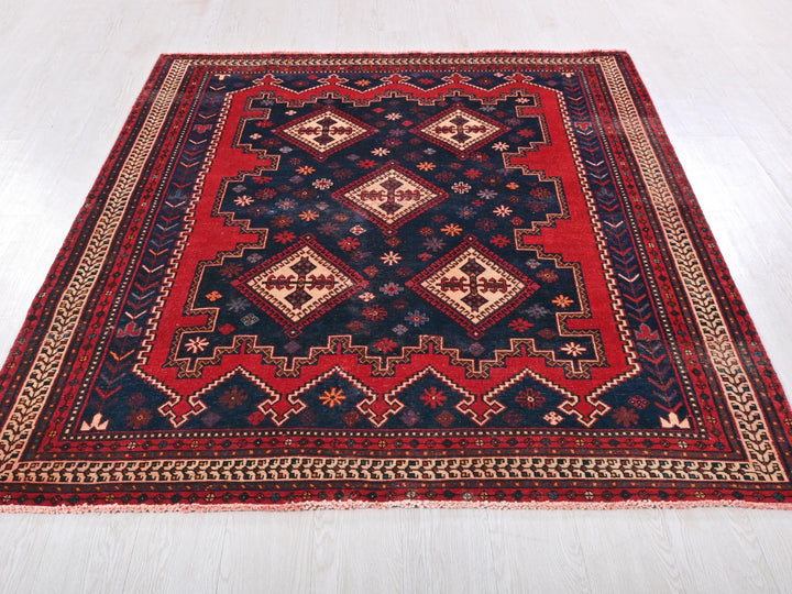 a red and blue rug on a white floor