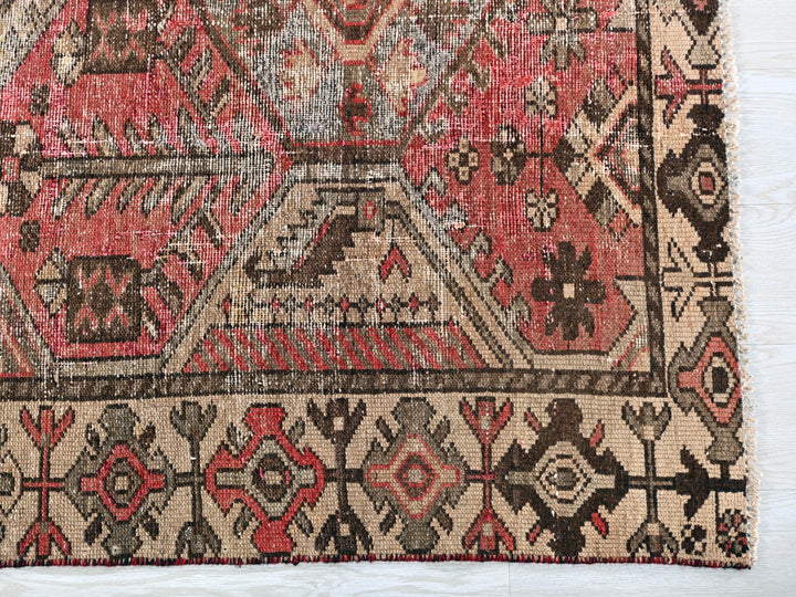 a red and brown oriental rug on a white floor