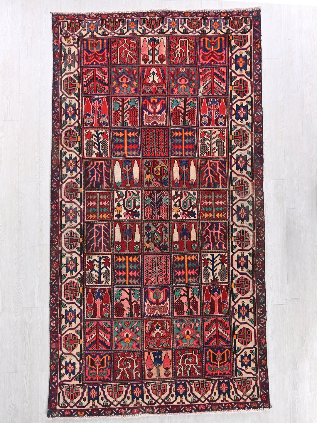 a red and blue rug hanging on a wall