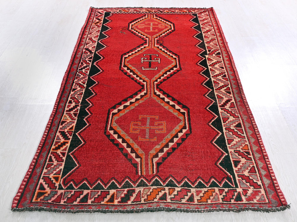 a red rug with a design on the middle of it